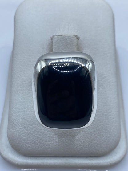 Anillo de plata .925 con ónix negro sobre dedo, mostrando el engaste minimalista