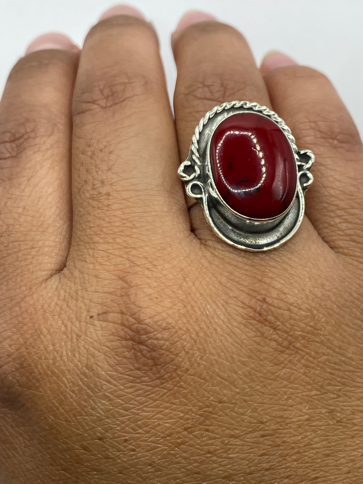 Anillo sobre fondo gris mostrando el Quinto .925 y el acabado pulido