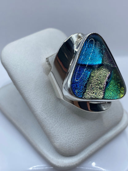 Vista frontal del anillo multicolor iridiscente mostrando los compartimentos de azul, verde y dorado
