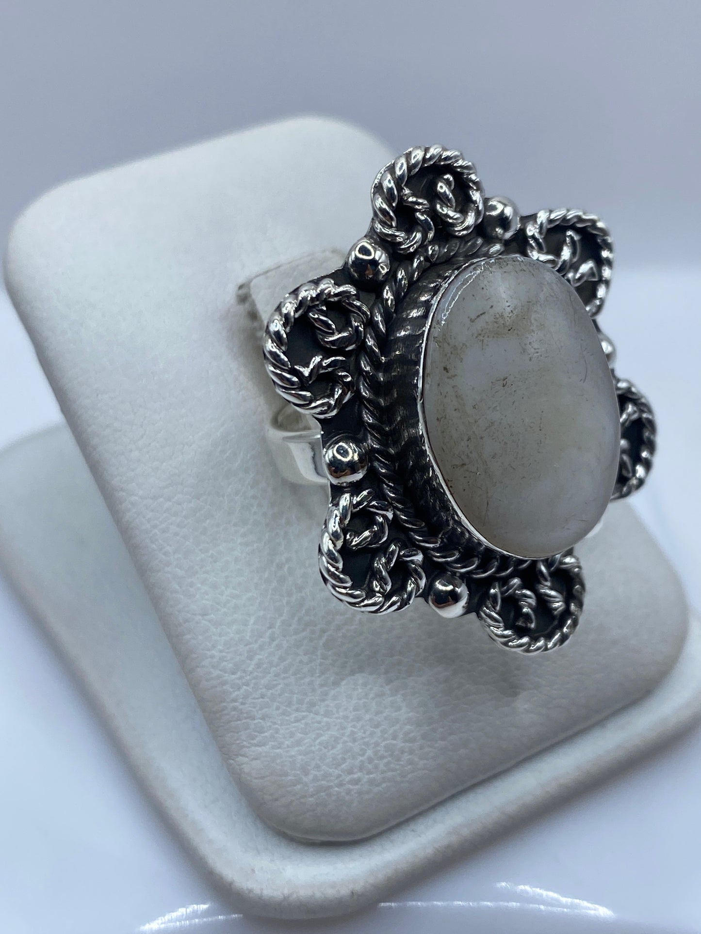 Vista lateral del anillo ajustable con detalle de las volutas de plata y engaste de perla