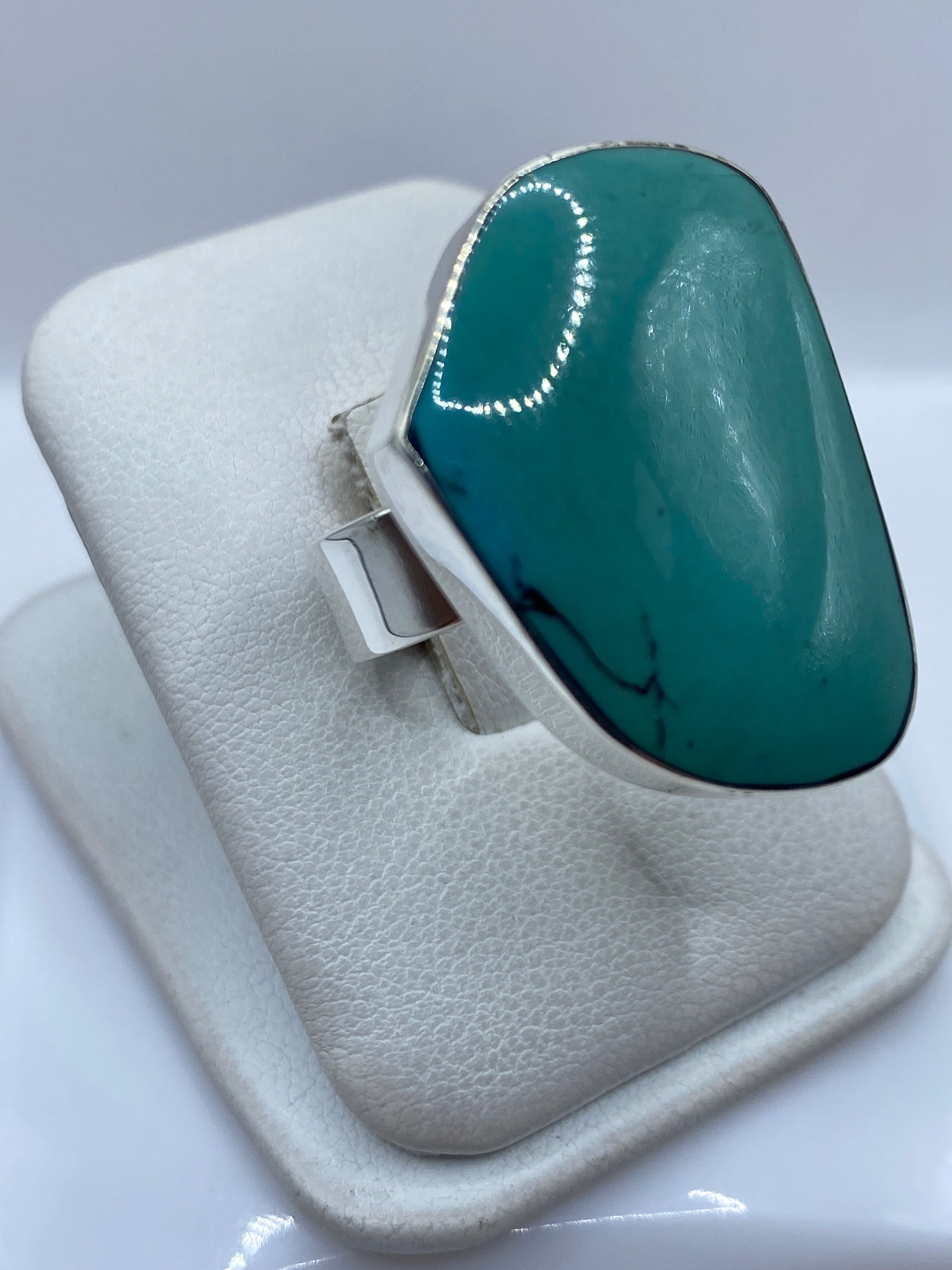 Detalle lateral del anillo ajustable mostrando el engaste a mano de la turquesa azul cielo