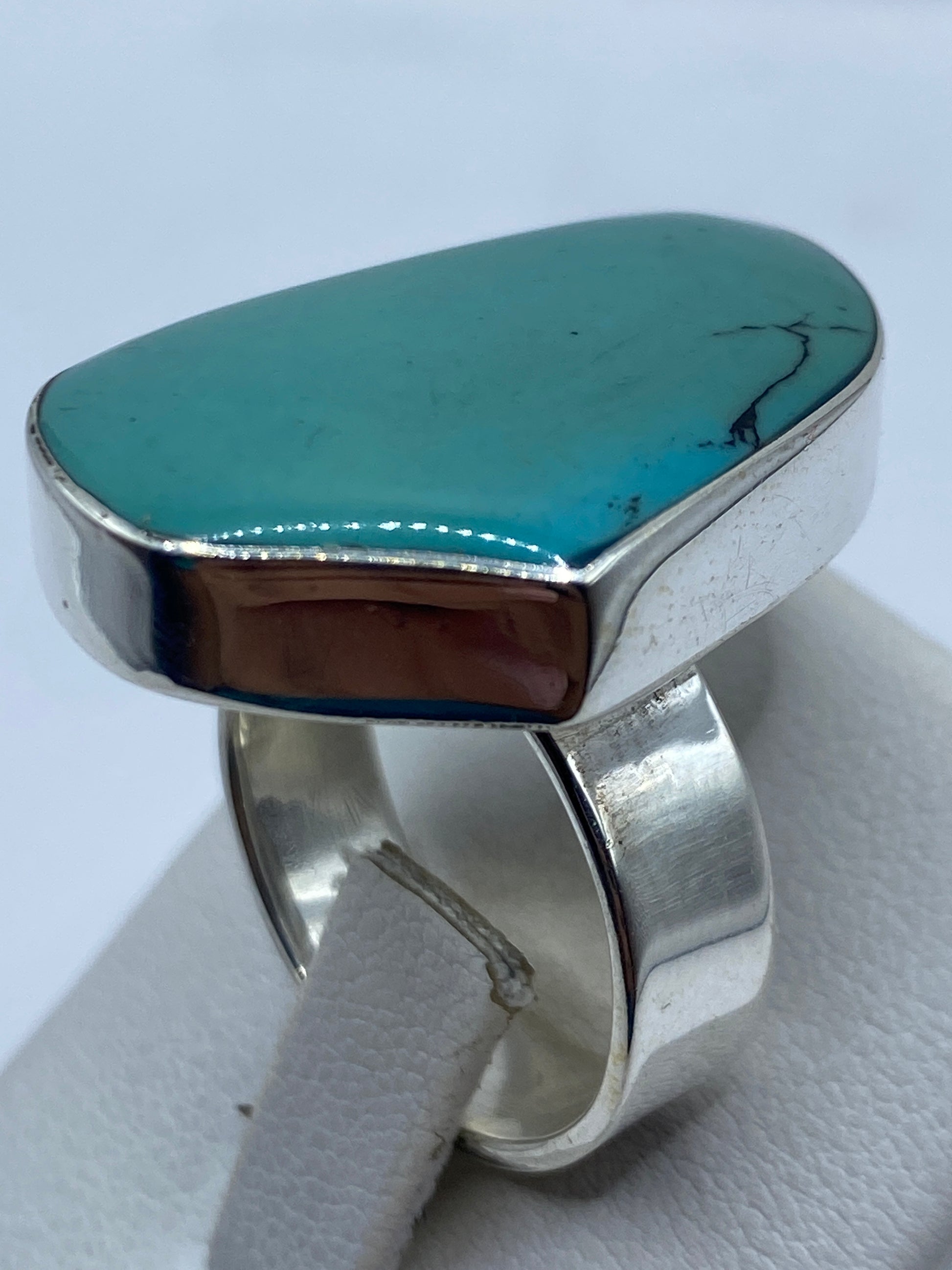 Anillo de turquesa ajustable en la mano de una mujer, mostrando el color azul cielo natural