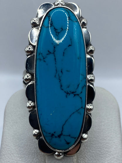 Detalle macro del engaste de turquesa azul cielo con vetas naturales en anillo de plata