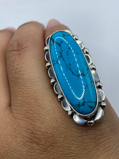 Anillo de plata turquesa puesto en dedo, mostrando el tono azul cielo de la piedra y el peso de la plata