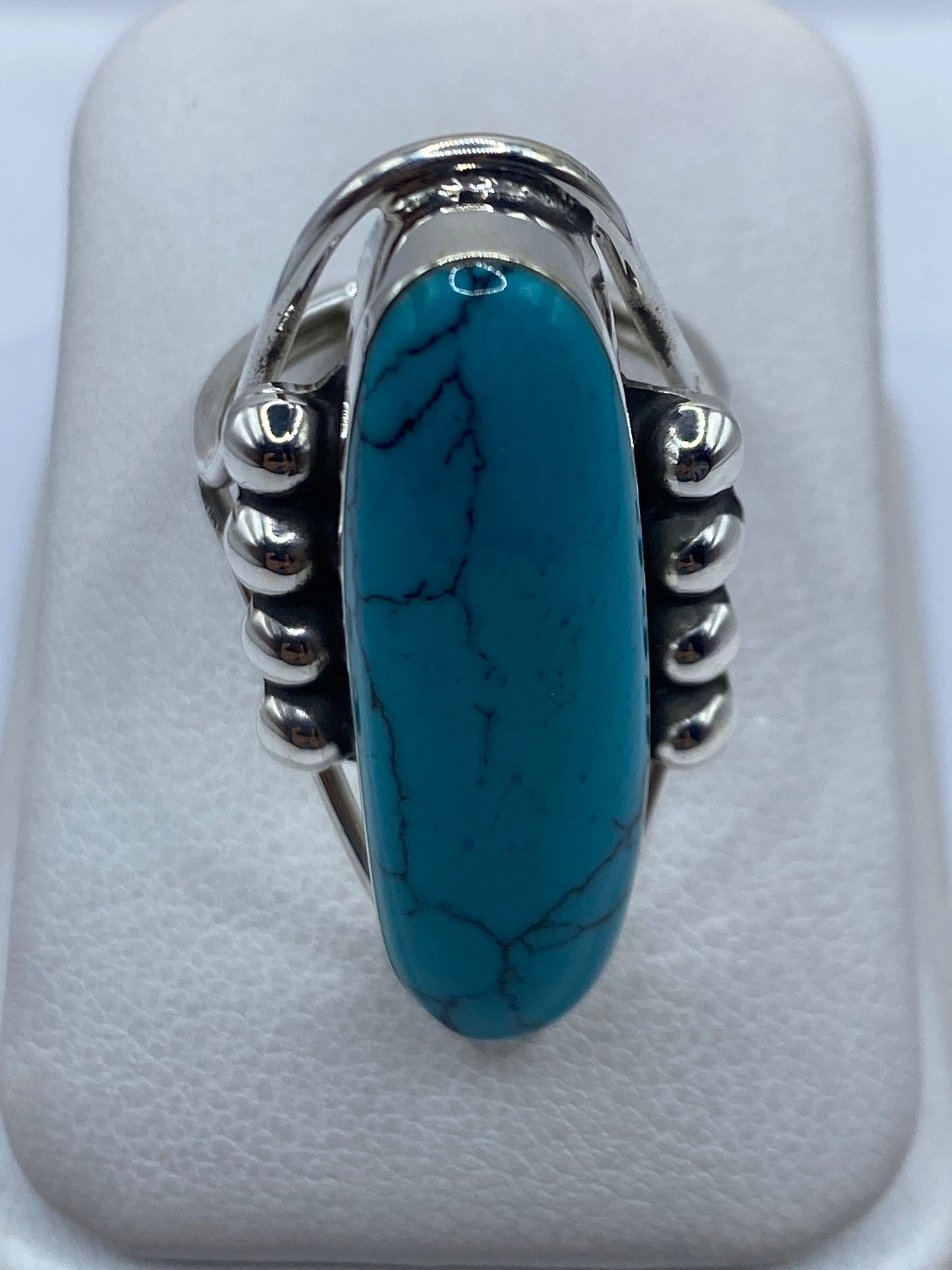 Anillo de plata .925 con turquesa azul cielo engastada en el centro, vista frontal sobre fondo blanco