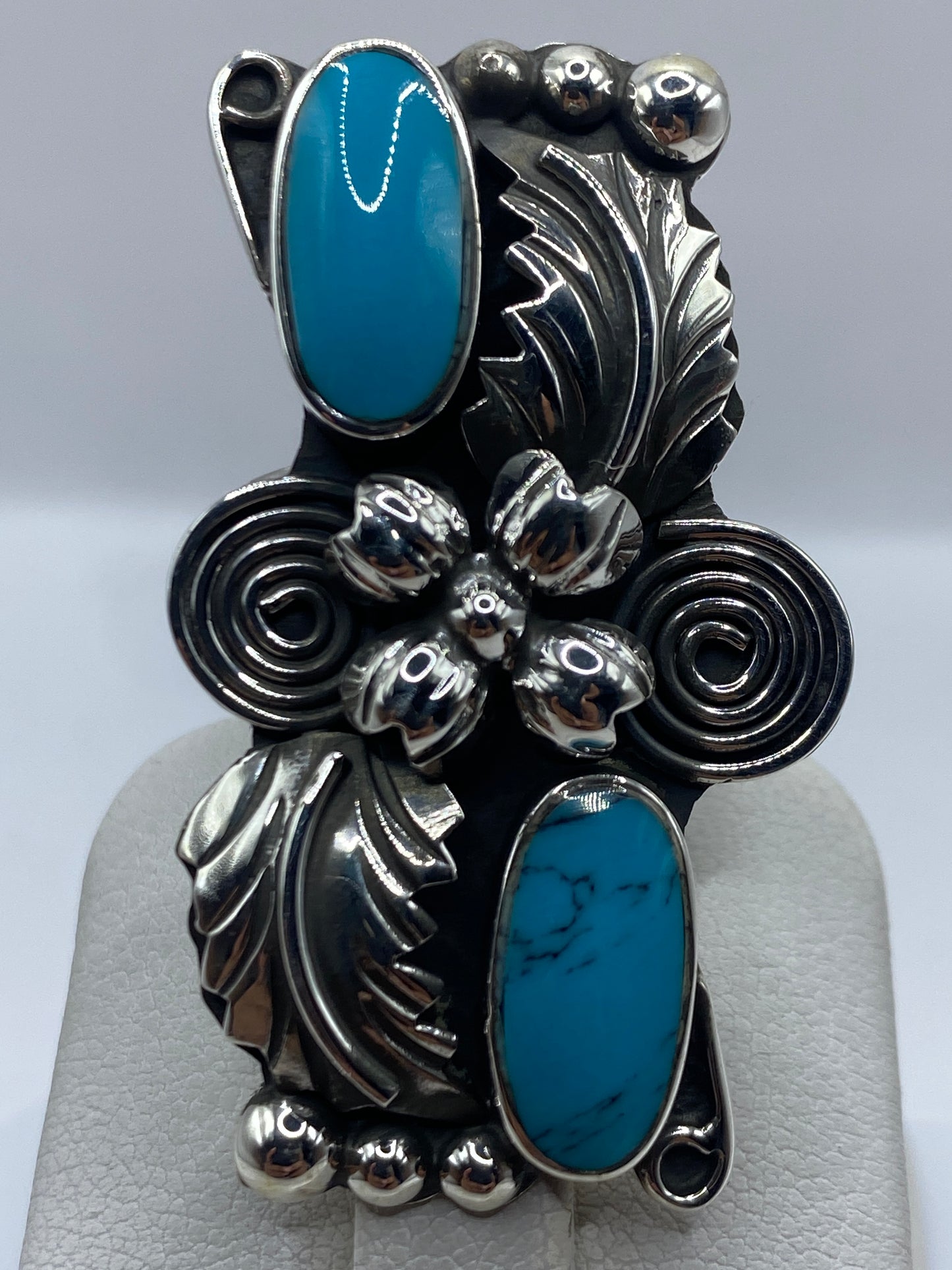 Anillo puesto en dedo, exhibiendo la turquesa azul cielo y los acabados artesanales de Taxco