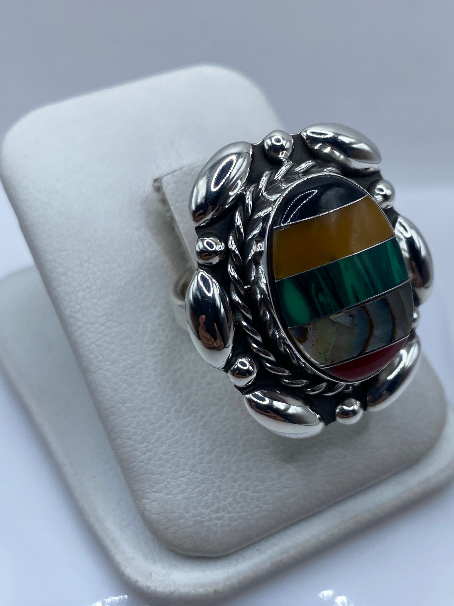 Detalle lateral del anillo ajustable mostrando el engaste a mano y las vetas de malaquita