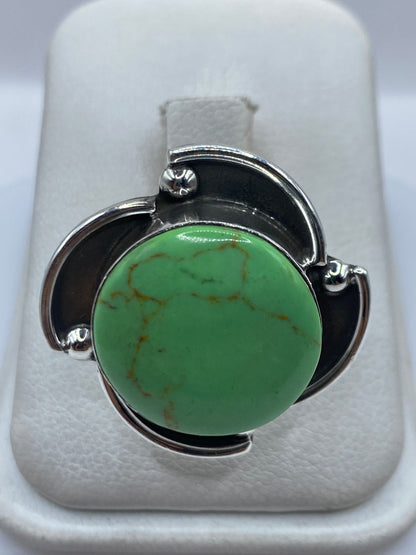 Anillo de plata .925 con piedra verde engastada, brazos arquitectónicos, en dedo de mujer