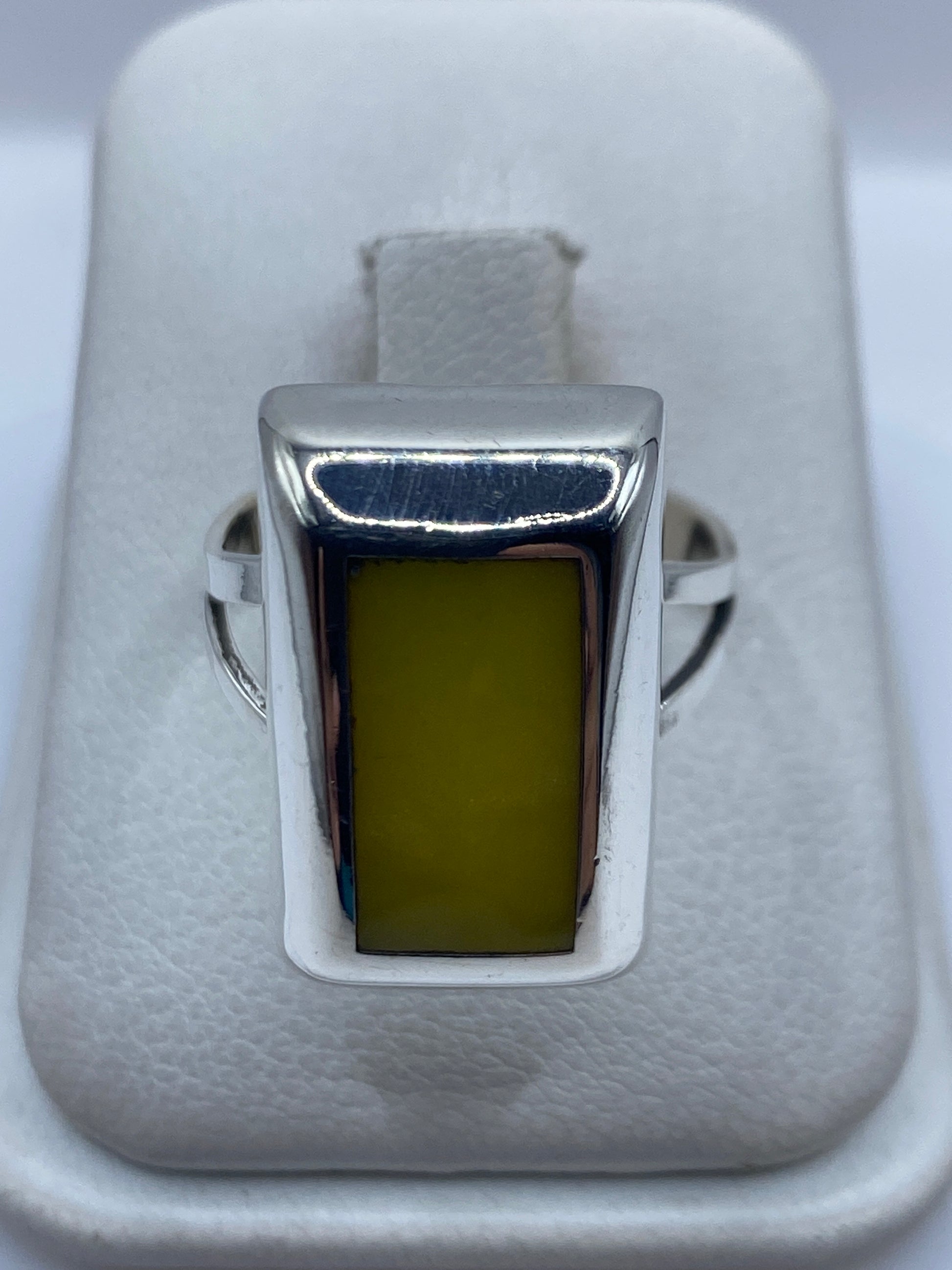 Anillo de plata cuadrado con piedra amarilla engastada, en estuche de terciopelo blanco
