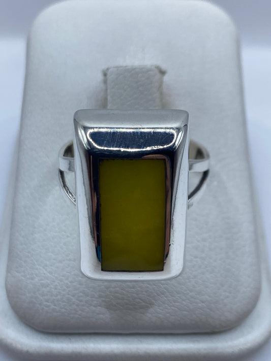 Anillo de plata cuadrado con piedra amarilla engastada, en estuche de terciopelo blanco