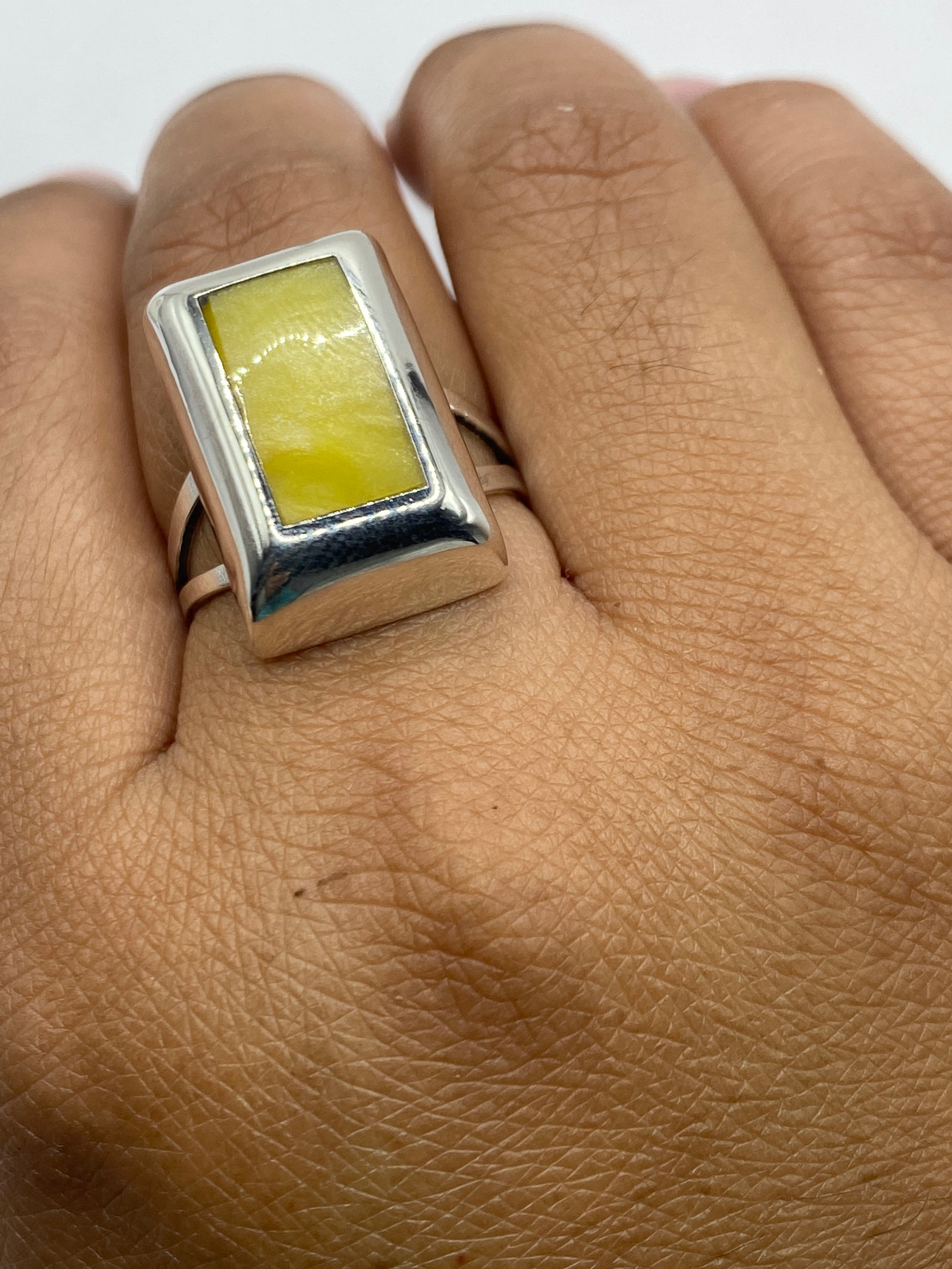 Anillo en dedo mostrando la piedra amarilla brillante y el acabado pulido