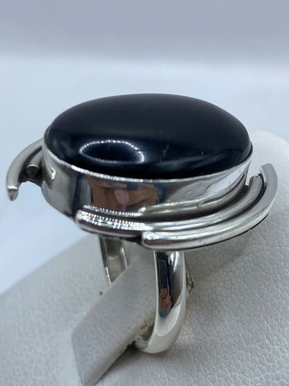 Anillo de ónix negro puesto en dedo, mostrando tamaño y brillo de la gema