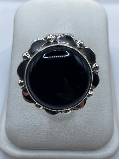 Anillo de plata con ónix negro engastado a mano, vista frontal sobre fondo blanco