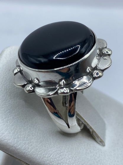 Anillo puesto en mano de mujer mostrando el contraste del ónix negro con la plata brillante