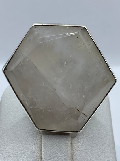 Anillo de plata hexagonal en mano de mujer, mostrando el ajuste y la piedra