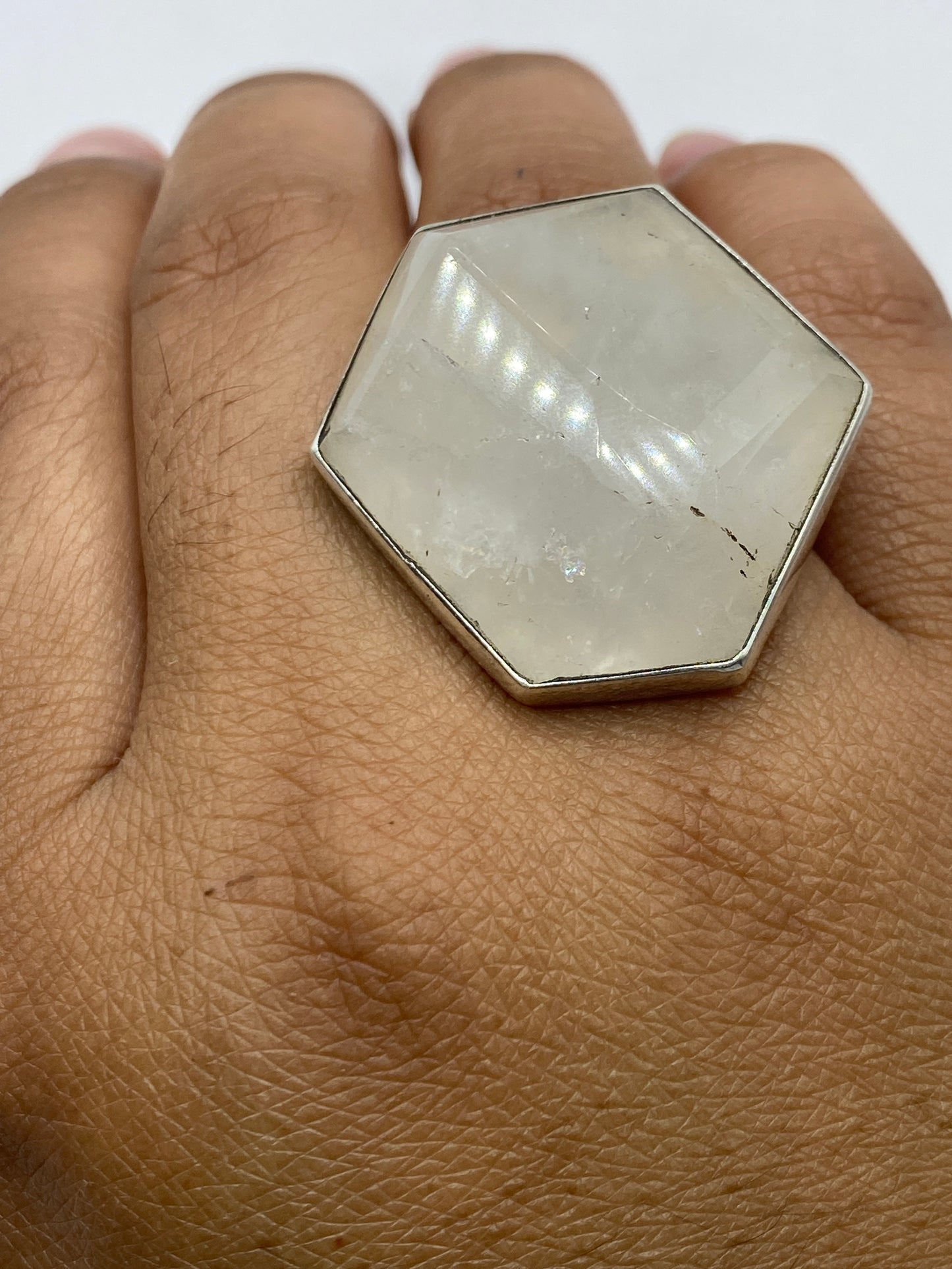 Anillo sobre superficie oscura: vista superior del marco de plata y el Quinto 950