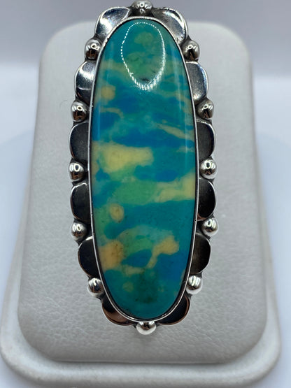Anillo de plata .925 con piedra azul oval engastada, vista frontal sobre dedo