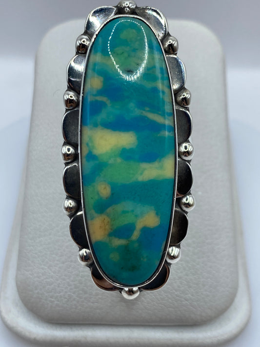 Anillo de plata .925 con piedra azul oval engastada, vista frontal sobre dedo