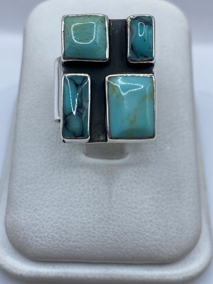 Anillo de plata con turquesa azul cielo en diseño geométrico de cuatro piedras visto desde arriba