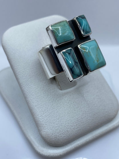 Anillo de plata .925 con turquesa azul cielo puesto en mano de mujer mostrando presencia