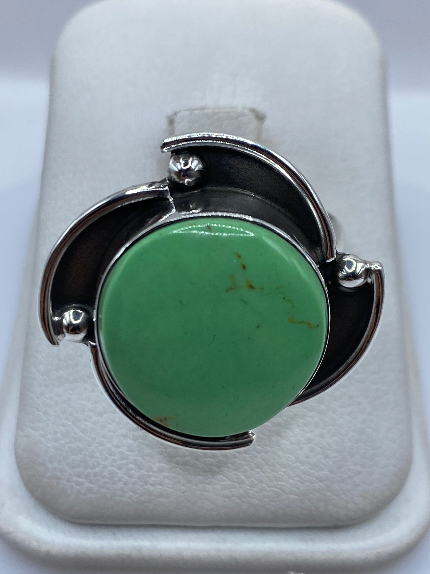 Anillo de plata ajustable con piedra verde engastada, vista frontal en estuche blanco
