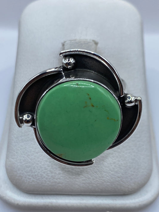 Anillo de plata ajustable con piedra verde engastada, vista frontal en estuche blanco