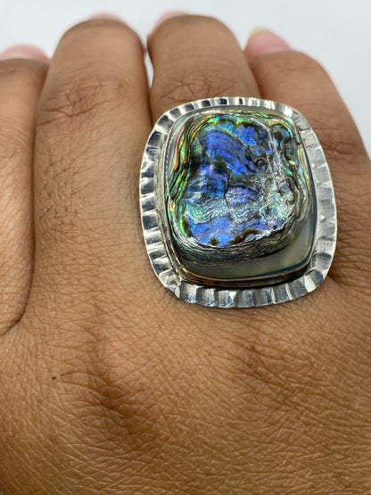 Anillo sobre fondo blanco mostrando toda la presencia de la piedra iridiscente