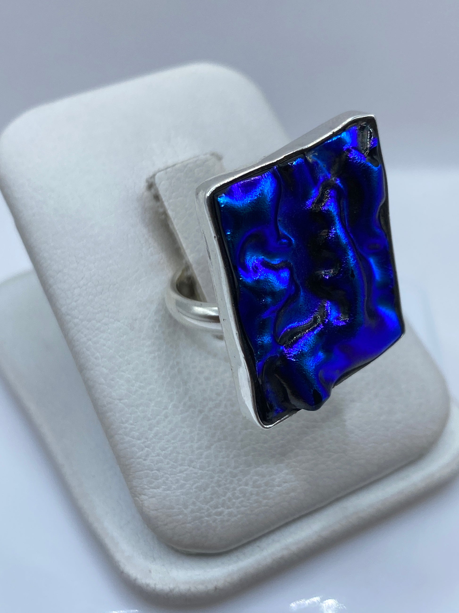 Vista frontal del anillo de plata con piedra azul intenso en dedo de mujer