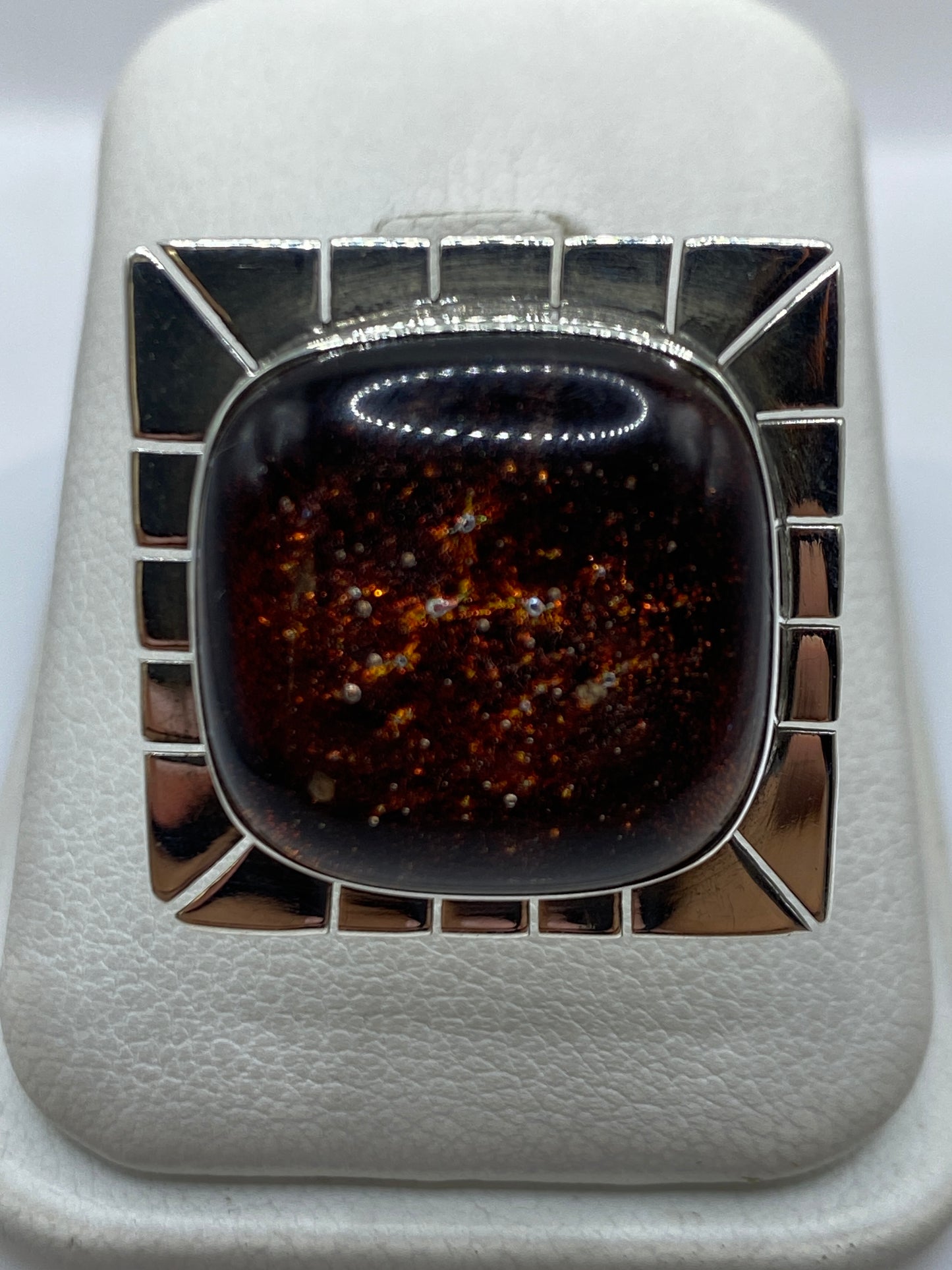 Anillo ajustable de plata con piedra incrustada en marco geométrico, vista frontal