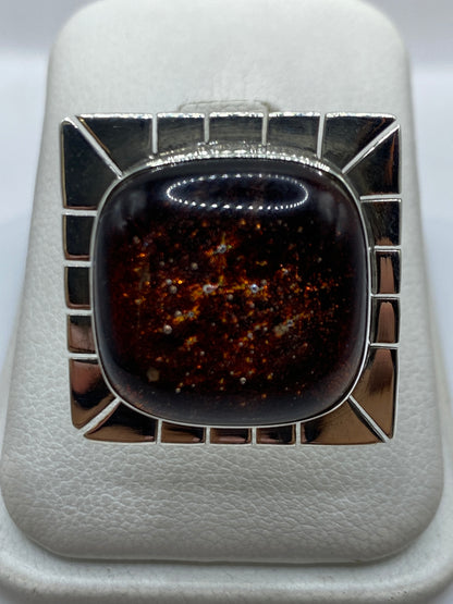 Anillo ajustable de plata con piedra incrustada en marco geométrico, vista frontal
