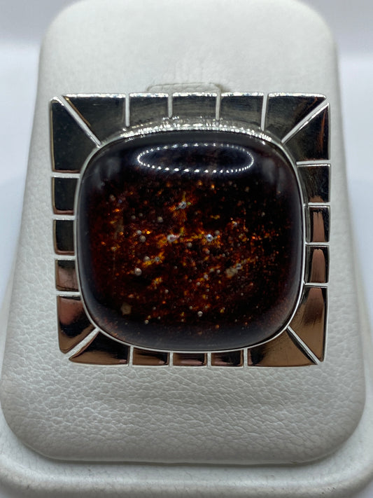 Anillo ajustable de plata con piedra incrustada en marco geométrico, vista frontal