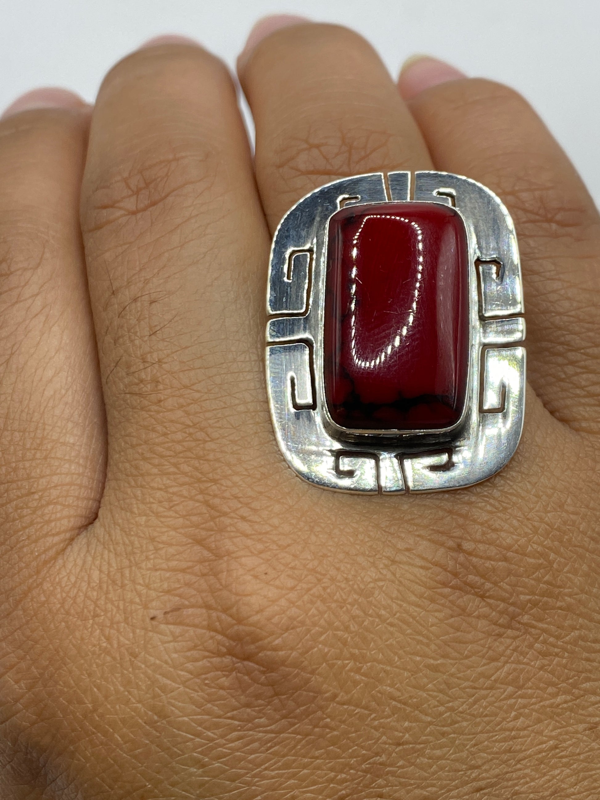 Vista lateral del anillo de plata con coral, marco geométrico de Taxco