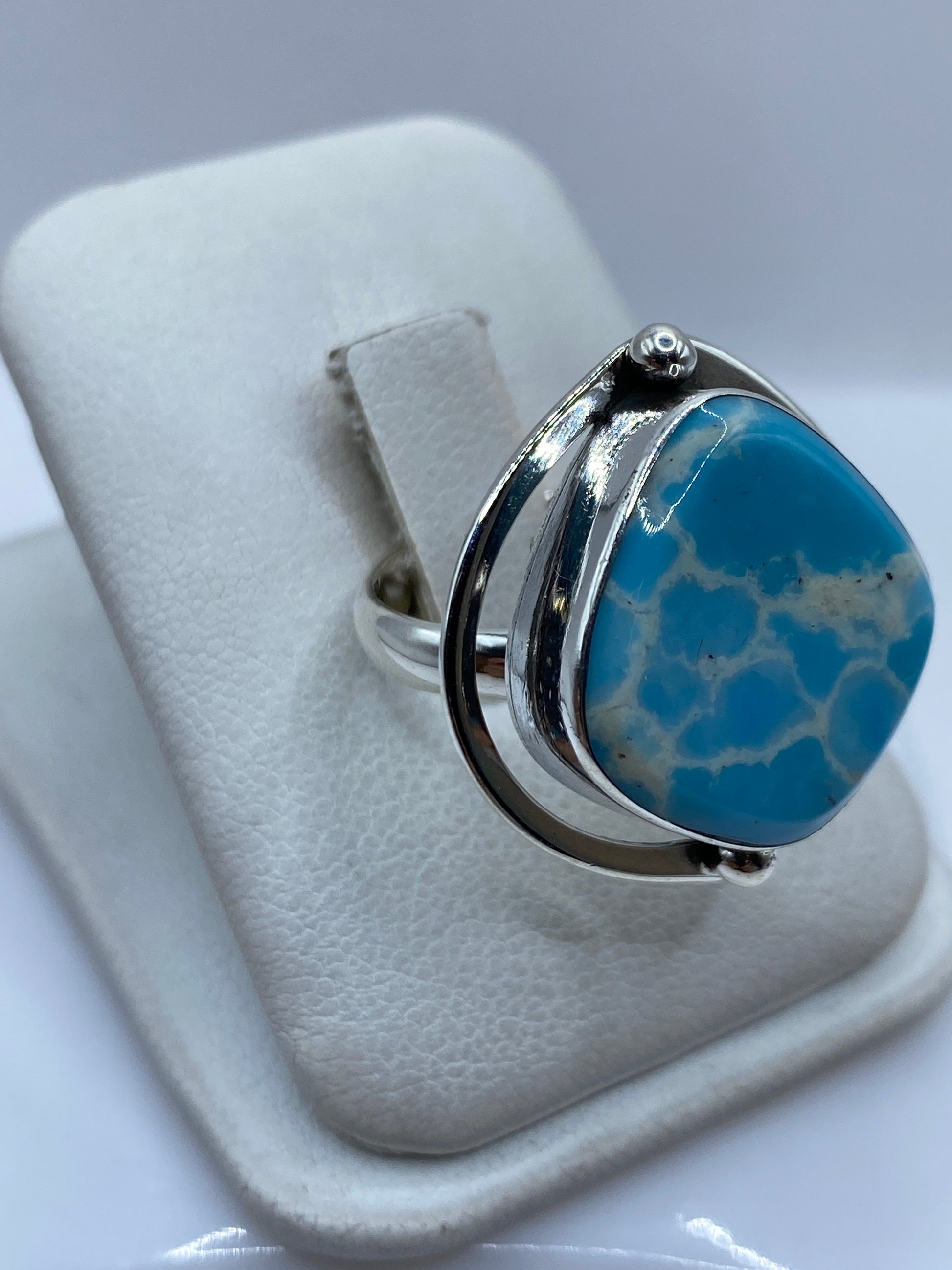 Anillo de plata en diseño ajustable con piedra azul cielo, vista lateral