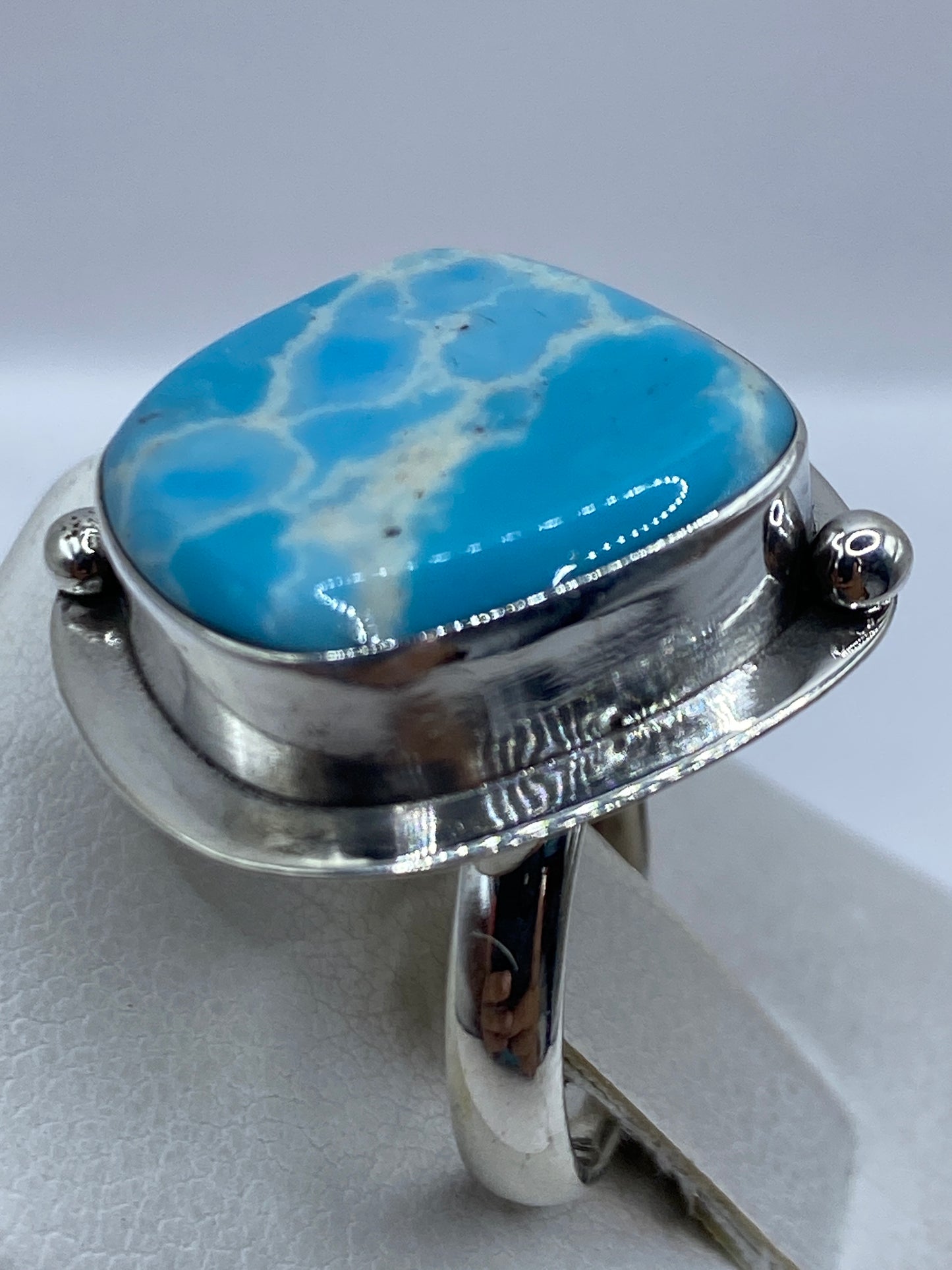 Detalle del engaste a mano de la piedra azul en marco de plata