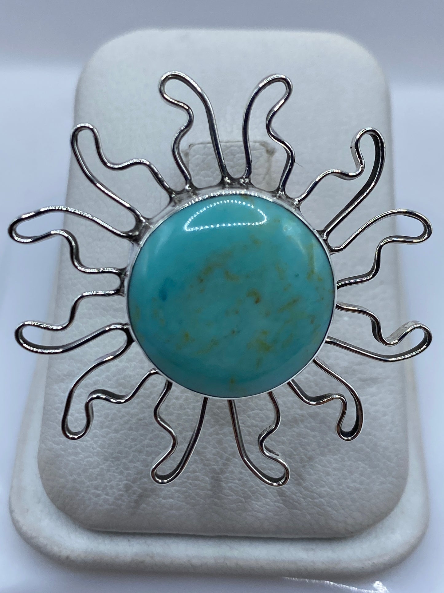 Anillo solar de plata .925 con turquesa azul cielo engastada, rayos ondulantes en la mano