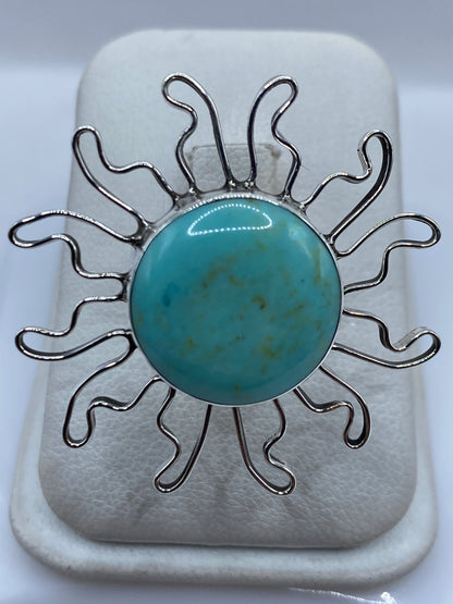 Anillo solar de plata .925 con turquesa azul cielo engastada, rayos ondulantes en la mano