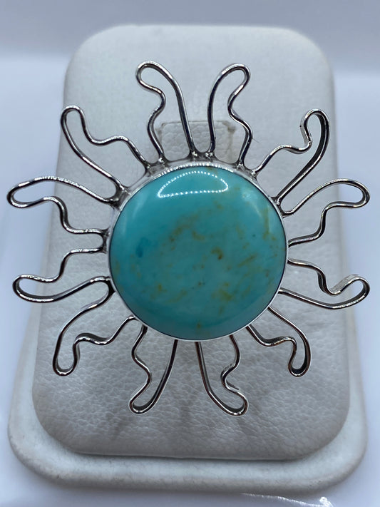 Anillo solar de plata .925 con turquesa azul cielo engastada, rayos ondulantes en la mano