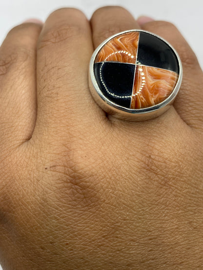 Anillo sobre fondo gris neutro revelando las vetas naturales de la piedra cafe
