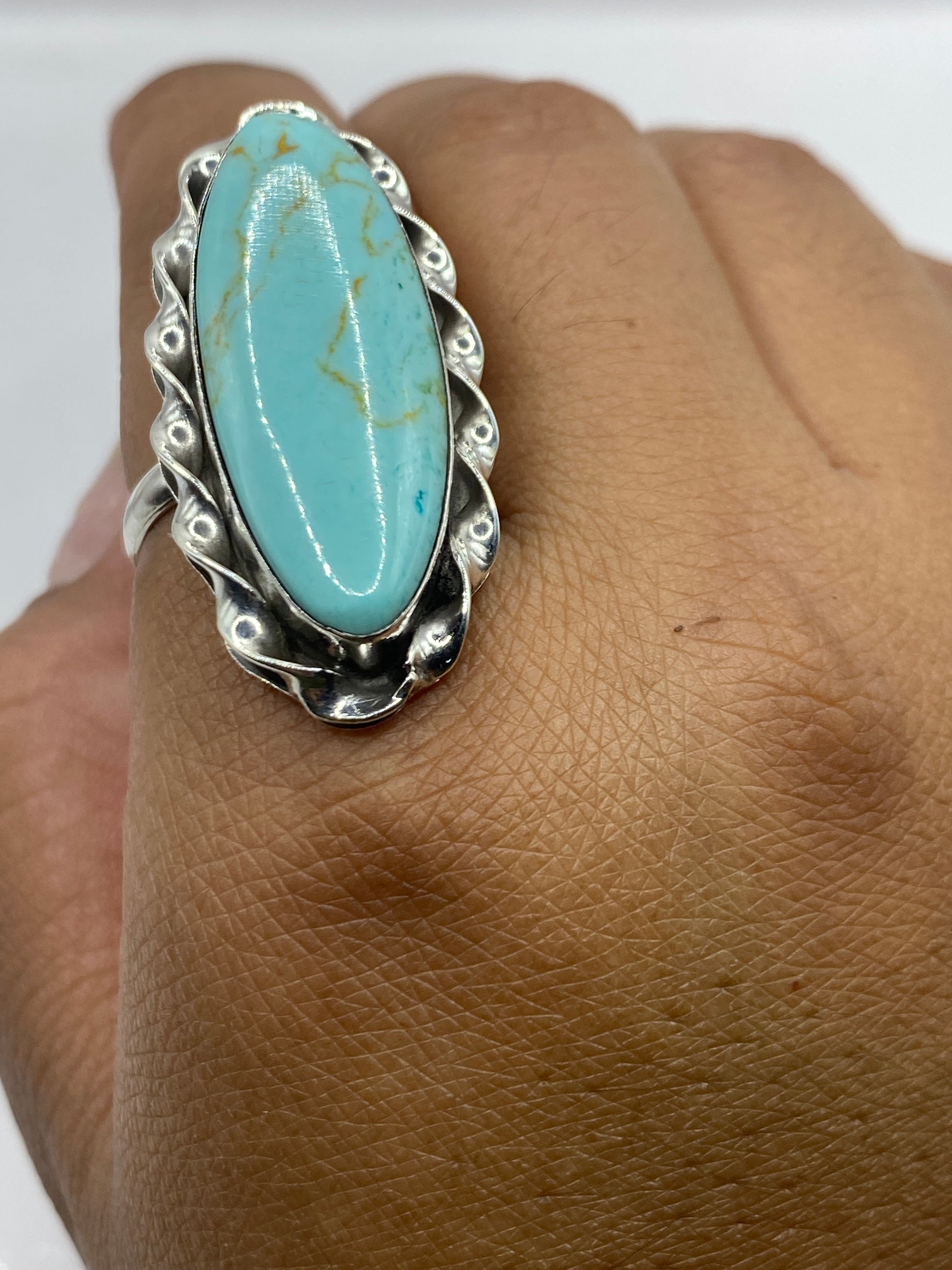 Anillo en dedo mostrando el color azul cielo de la turquesa con vetas naturales