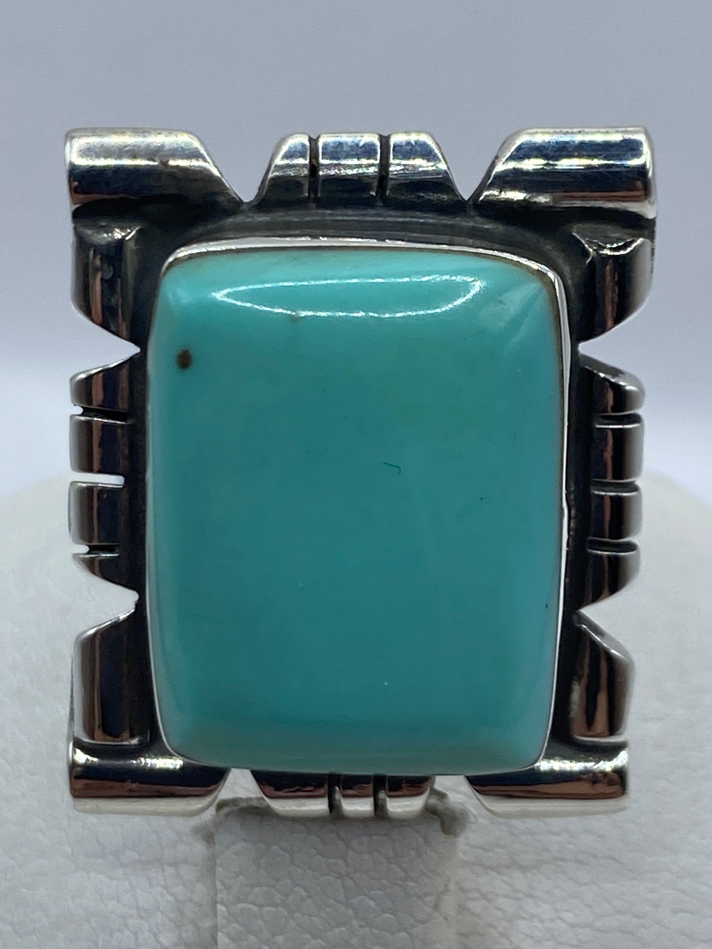 Anillo puesto en dedo de mujer, turquesa azul cielo brillando contra la piel