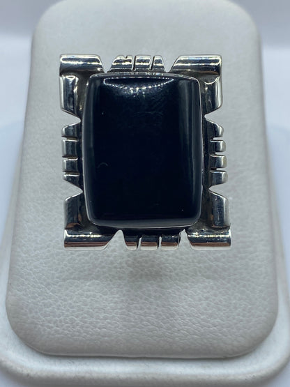 Anillo de plata .925 ajustable con onix negro engastado, visto desde arriba sobre fondo blanco