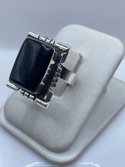 Detalle lateral del anillo mostrando el engaste a mano del onix y las líneas geométricas de plata