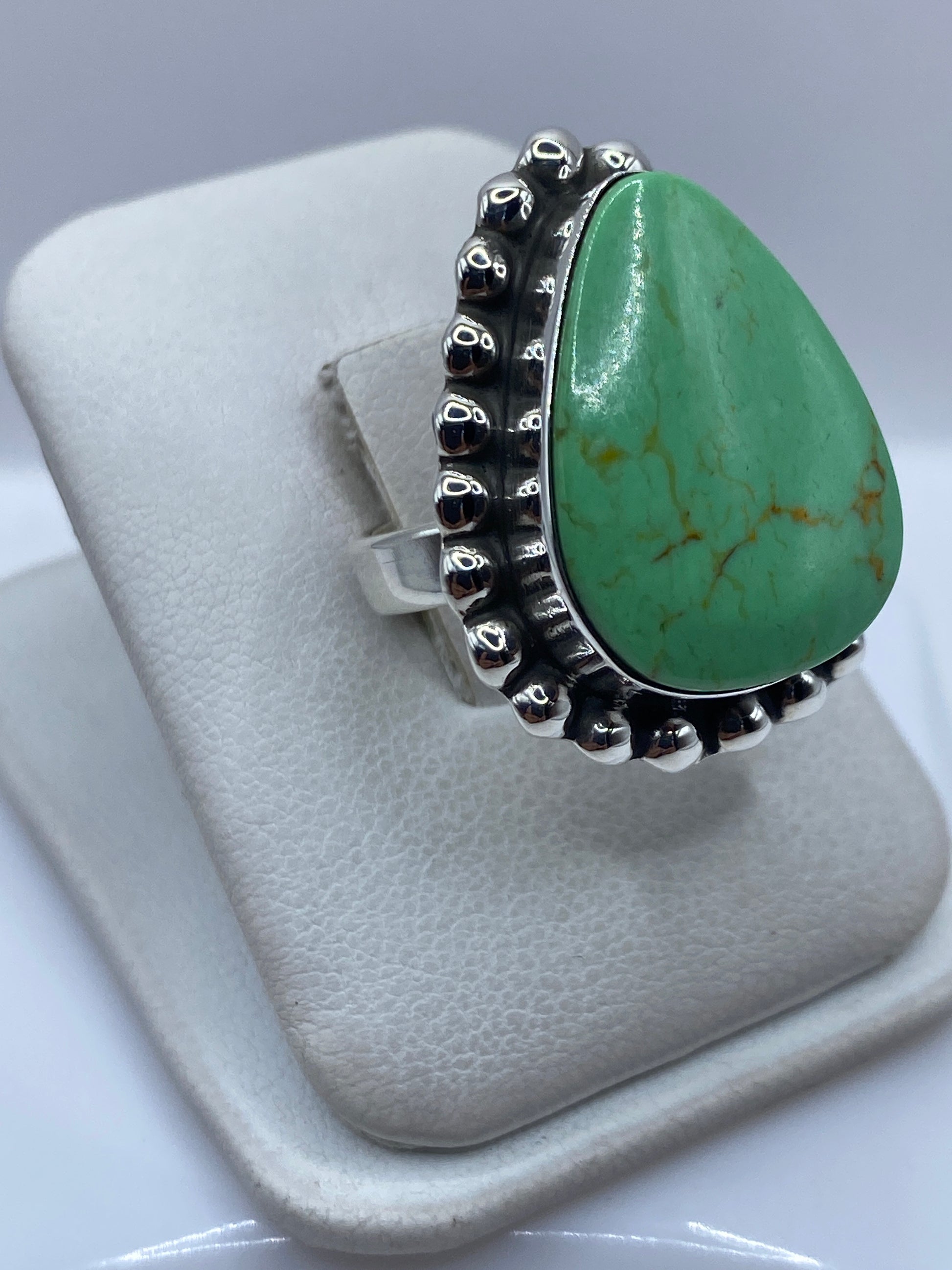 Detalle del engaste de la piedra verde en plata .925, mostrando el trabajo a mano