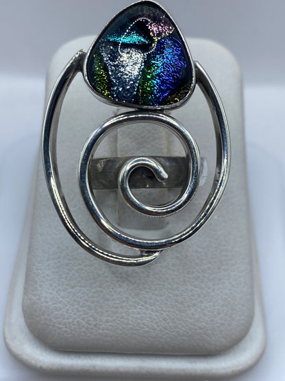 Anillo de plata espiral con incrustación de piedra multicolor en dedo de mujer