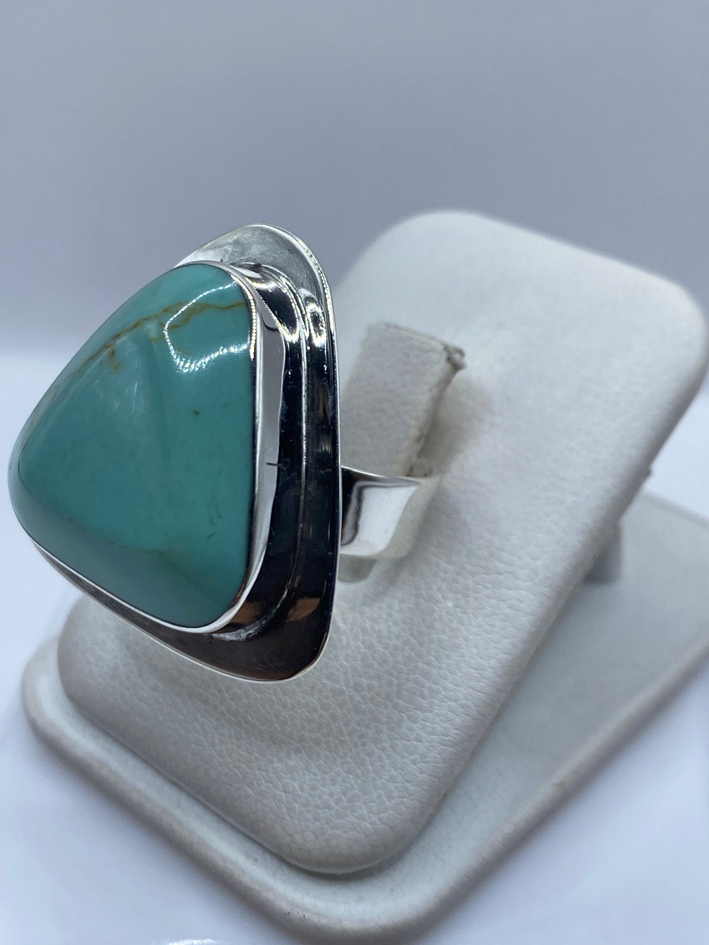Anillo de plata .950 con turquesa azul cielo puesto en dedo, mostrando el engaste a mano