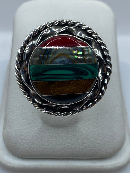 Anillo de plata ajustable con malaquita verde cabujón en mano de mujer