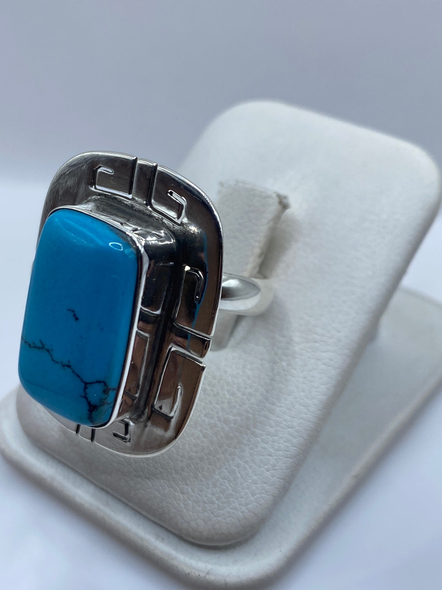 Detalle lateral del anillo ajustable mostrando el engaste a mano de la turquesa en plata