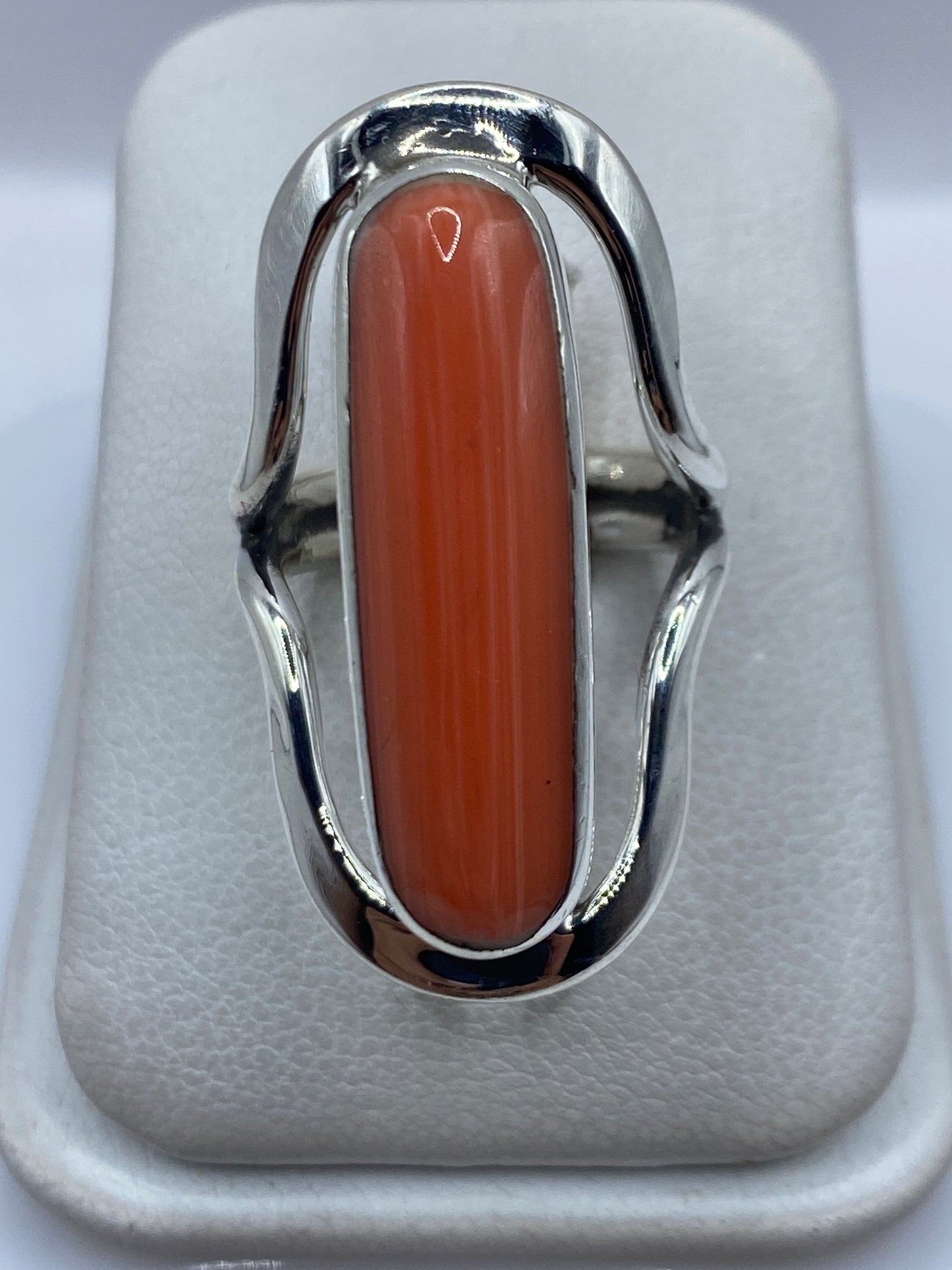 Anillo de plata .925 con coral naranja rojizo engastado, vista frontal sobre fondo blanco