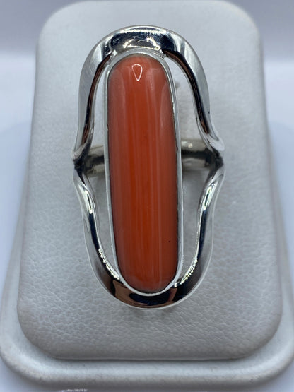 Anillo de plata .925 con coral naranja rojizo engastado, vista frontal sobre fondo blanco