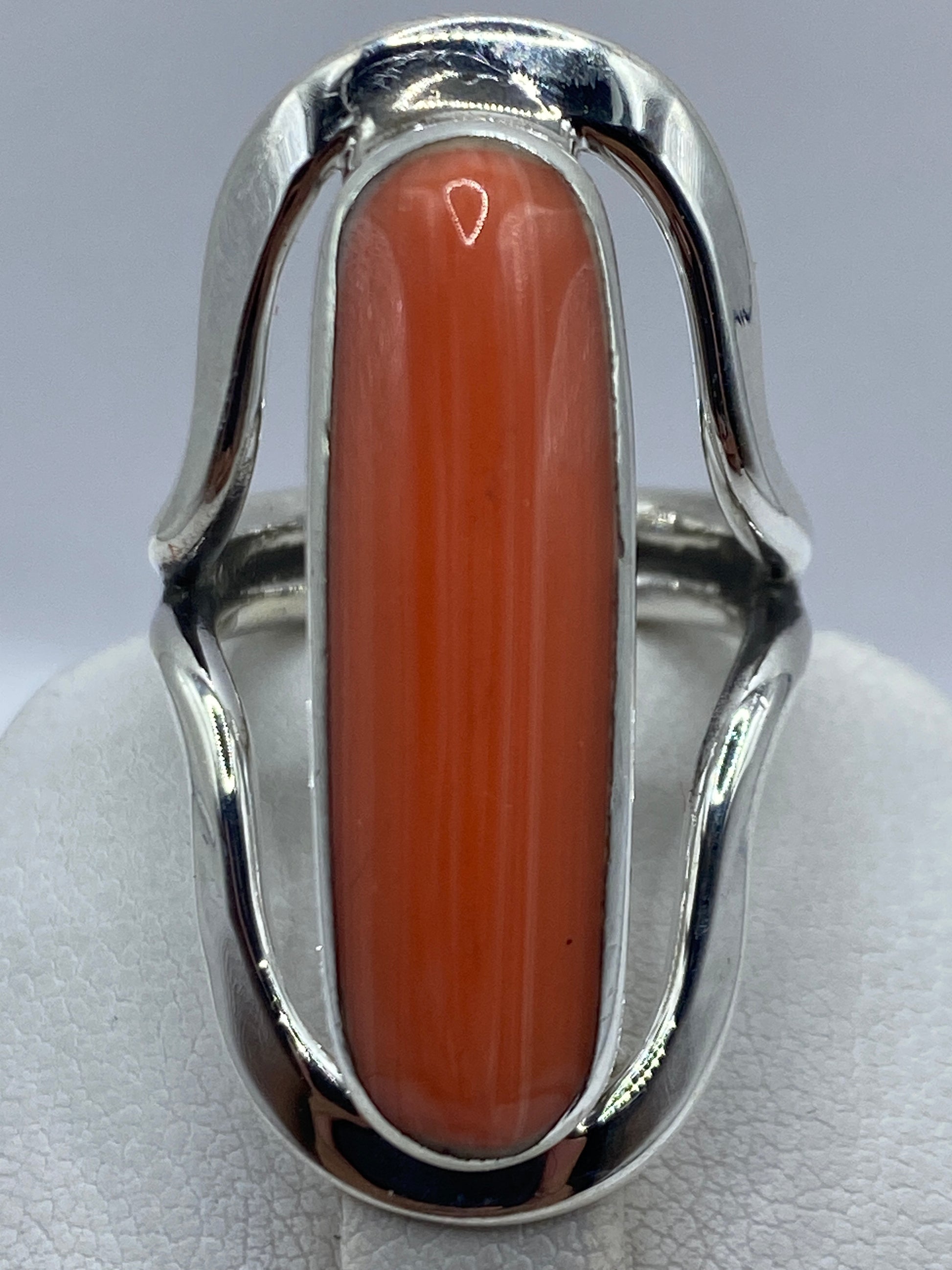 Anillo de coral en plata luciendo en dedo, mostrando el color cálido naranja rojizo
